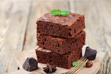 Chocolate brownie cake, dessert with nuts on wooden background.