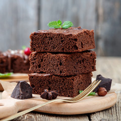 Chocolate brownie cake, dessert with nuts on wooden background.