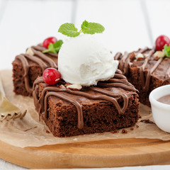 Chocolate brownie cake, dessert with nuts on wooden background.