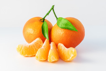 Whole tangerines or mandarines orange fruits and peeled segments isolated on white background