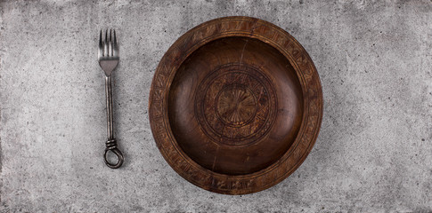 cutlery and wooden plate on a gray table