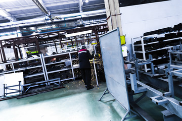 Bus industry worker in protective clothing with welding arm on a