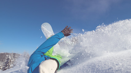 CLOSE UP: Extreme male cross country snowboarder crashes into fresh snow