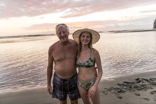 A 60s Man at the beach having good time with daughter on vacancy