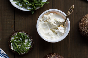 Cottage cheese. Cheese cream on rye bread. Health food. Vegetarian sandwich with rocket salad. Idea for healthy breakfast. Rustic breakfast. Countryside snack.