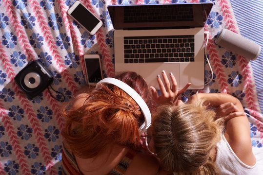 Women browsing laptop in headphones