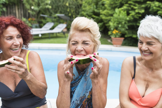 Happy Senior Women Eating Watermelon In The Home Garden