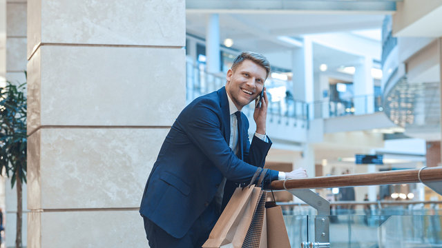 Young smiling businessman with shopping bags