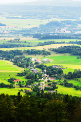 Misty valley of  Broumovsko in Czech Republic with fields and green meadows. Scenic picturesque countryside landscape. Vast panorama of Ruprechtice village in the Sudetes. Aerial view.