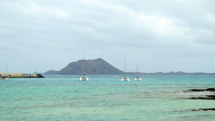 View of the Island Lobos and sailboats from Fuerteventura, Corralejo.