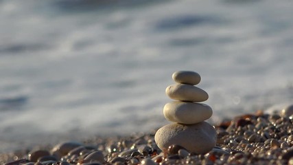 Sea wave on the beach breaking down building of overlapped stone pebbles 4k - Powered by Adobe