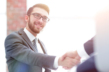 Two business colleagues shaking hands during meeting.