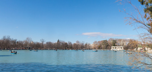 Beautiful picture of tourists on boats at pond of the Parque del Buen Retiro - Park of the Pleasant Retreat in Madrid, Spain