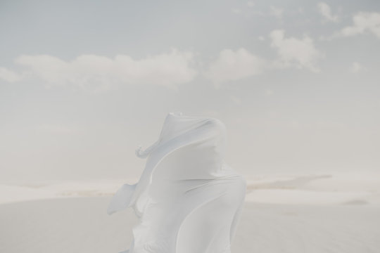 Mysterious Portrait - white on white concept with a white flow fabric hiding a human silhouette face