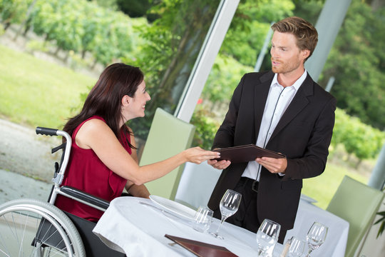 smiling woman in a wheelchair in a restaurant