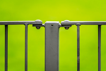 Metal gate fence detail over green background