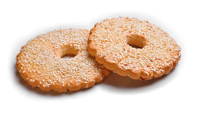 round gingerbread with sesame seeds lie on white paper