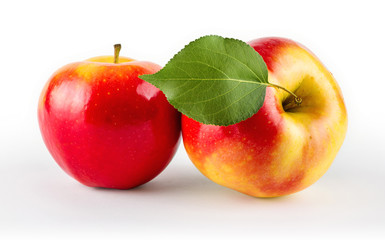 Ripe juicy apples with leaves, close-up, isolated on white background.