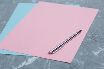 pen on a pink sheet, on a gray textured background