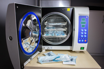 Sterilizing medical instruments in autoclave, Tongs for manicure on the background of a medical autoclave