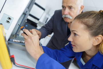 woman apprentice computer repairer monitored by teacher