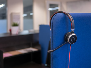 Computer or telephone headset hangs in an office or call center.