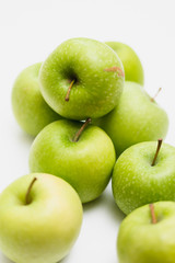 Close up shot of organic green yellow Granny Smith or Golden Delicious apples with little blemishes on white background