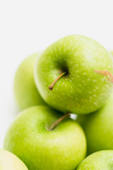 Close up shot of organic green yellow Granny Smith or Golden Delicious apples with little blemishes on white background