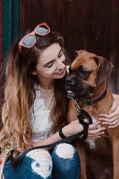 A young woman posing for pictures with her dog in the city