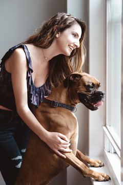 A young woman and her dog at home