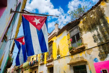 Tuinposter Cuban flags and colorful decaying buildings in Old Havana © kmiragaya