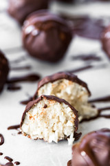 Coconut Chocolate Covered Glazed Vegan Balls Cut in Half on White Parchment Paper