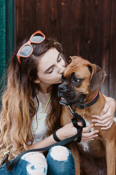 A young woman posing for pictures with her dog in the city