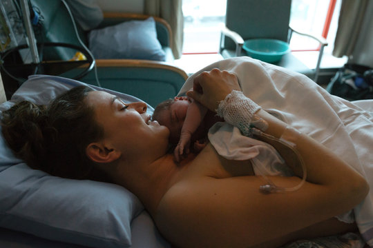 Brand new mother and child after delivery in hospital room