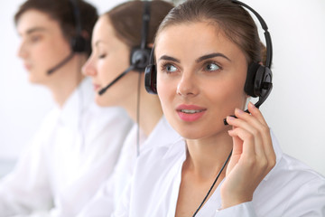 Call center. Focus on beautiful woman in headset