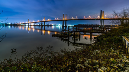 Fototapeta premium The Golden Ears Bridge, conecting Maple Ridge to Langley. Long exposure at night, reflecting into Fraser River.