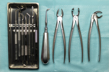 a medical tray with dental instruments, a mirror and a probe. surgical instruments for tooth extraction