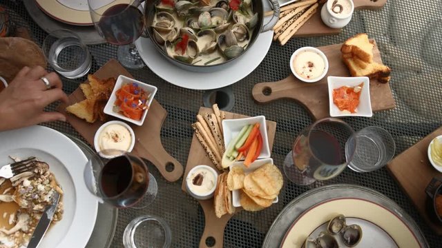 Shared food platter with mussels, red wine, chips, carrots and bread.