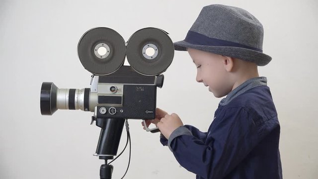 Little child looking at video camera, funny professional repair or broke camera