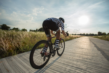 Fototapeta premium Man And bicycle on a rural road with grass