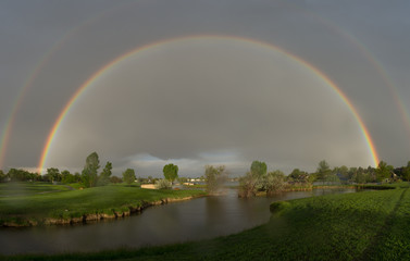 double rainbow over park lake