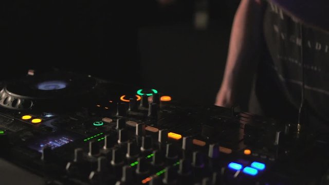 DJ hands on mixer and decks