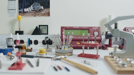 Watchmaker's desk of equipment and tools, camera dolly across