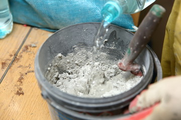 Grouting ceramic tiles on the floor by a man.