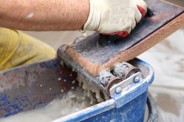 Grouting ceramic tiles on the floor by a man.