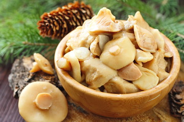 Pickled mushrooms in a wooden bowl
