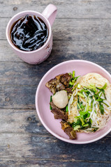 Thai style dry beef noodle on wooden table