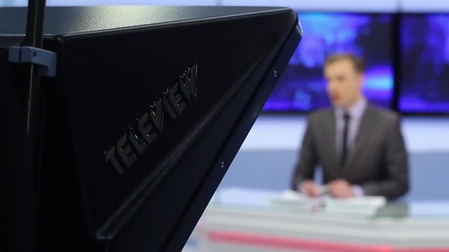 Male silhouette of the presenter reads on a teleprompter.TV studio. Actual events.