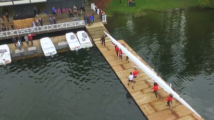 Team of rowers carrying their boat back into boathouse - Powered by Adobe