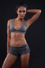 Fototapeta na wymiar female body of athlete on a dark background